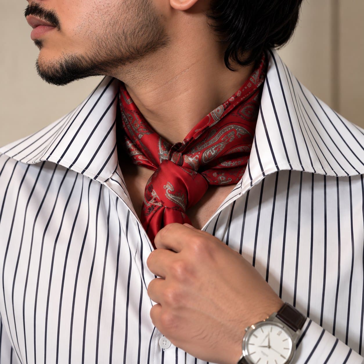 The wide spread collar, scarf tied.